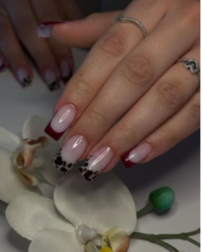 Zarte rosa French-Maniküre mit gepunkteten Spitzen.
