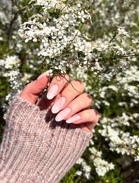 Zartrosa Maniküre mit Frühlingsblüten.