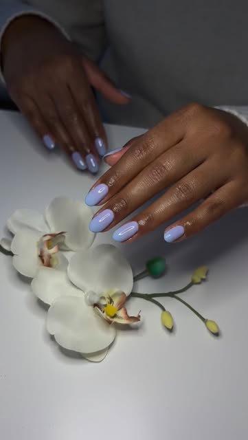 Lavendelfarbene Maniküre mit weissen Orchideen.